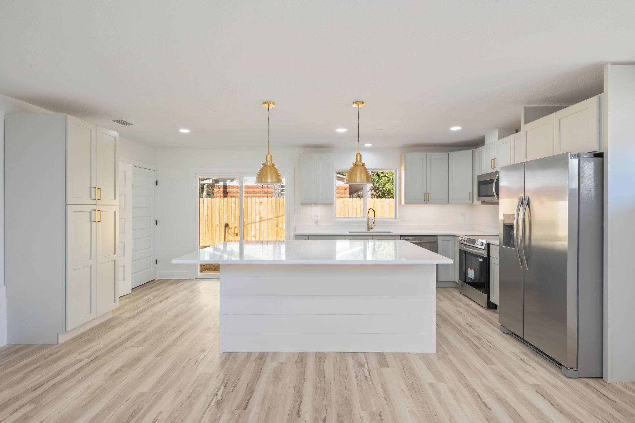 118 Ferry Road Northeast Fort Walton Beach, FL 32548 - Photo 14 of 51 a large kitchen with stainless steel appliances kitchen island a large counter top and wooden floors