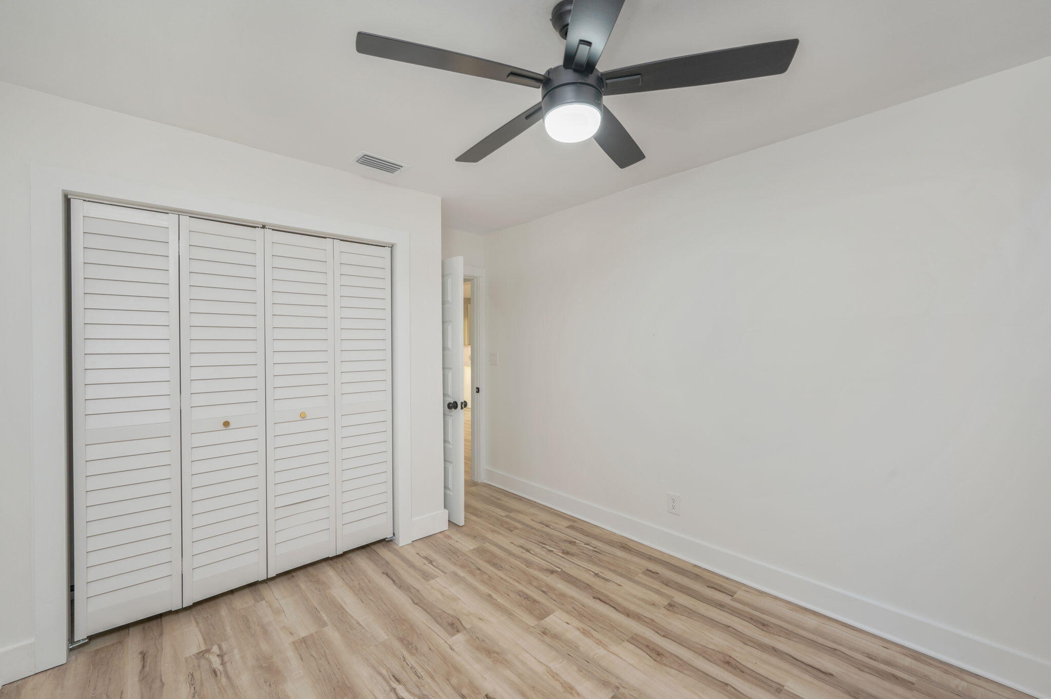 118 Ferry Road Northeast Fort Walton Beach, FL 32548 - Photo 27 of 51 an empty room with wooden floor closet and ceiling fan