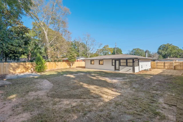a view of house with backyard and glass windows