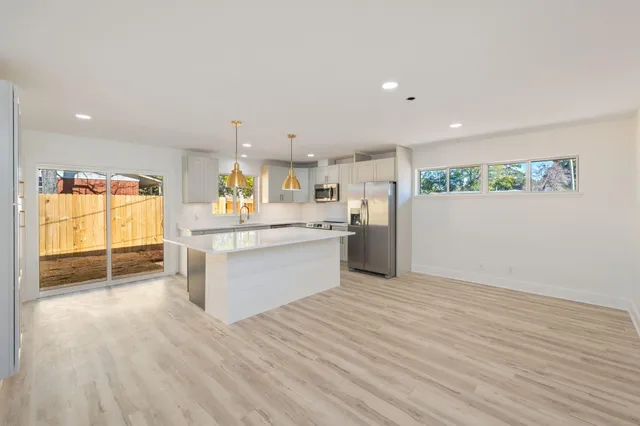 a view of kitchen with wooden floor electronic appliances and window