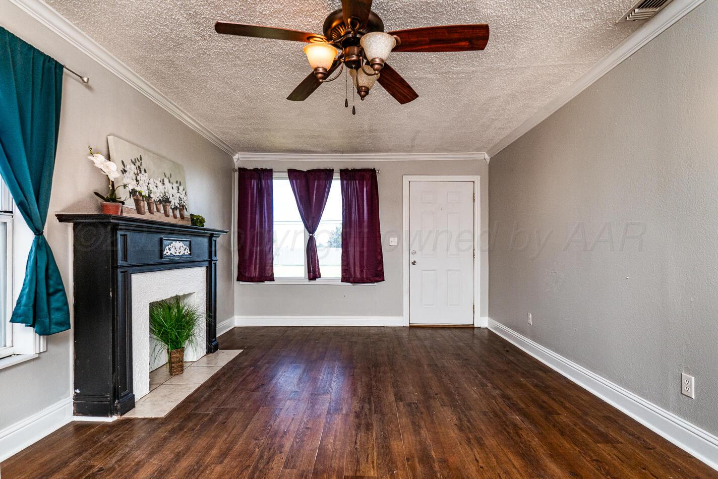 8015 Upton Road Amarillo, TX 79119 - Photo 2 of 16 a view of livingroom with window fireplace and hardwood floor