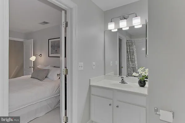 a spacious bedroom with a bed and a lamp