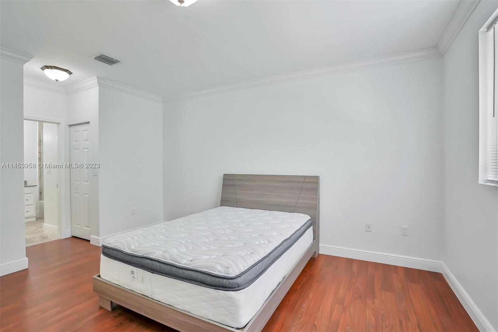 3012 Elizabeth Street, Unit 3012 Miami, FL 33133 - Photo 15 of 27 a bedroom with a bed and wooden floor