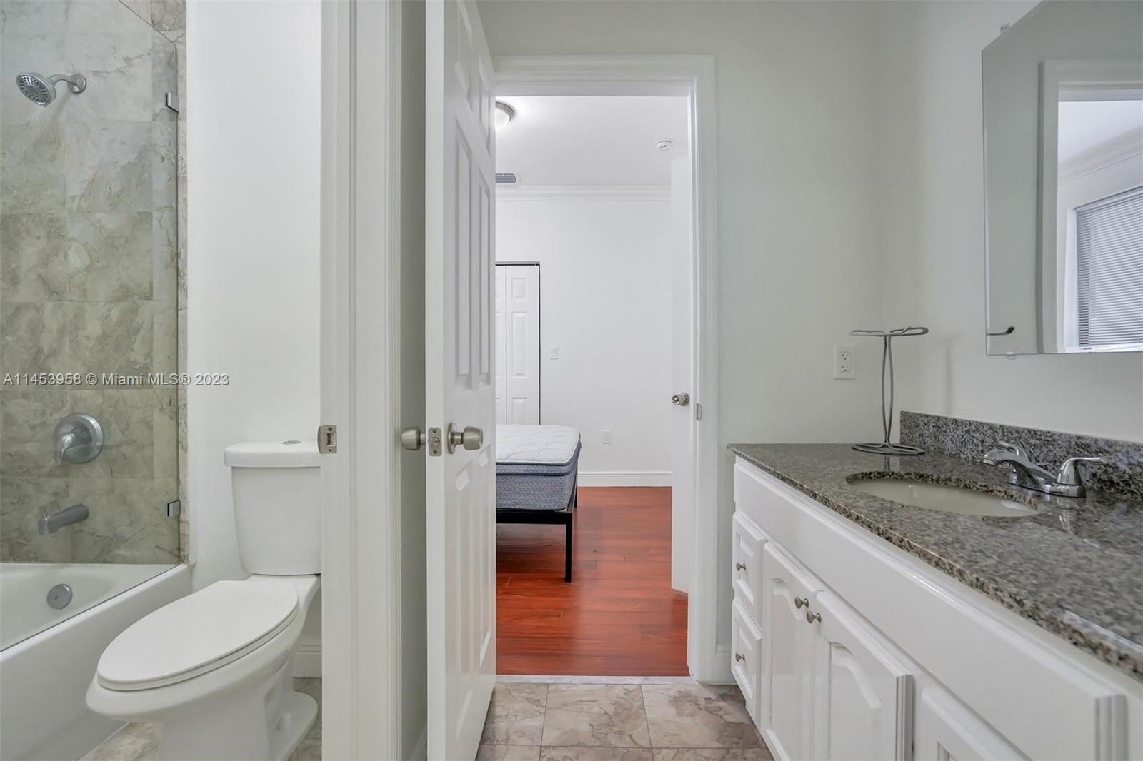 3012 Elizabeth Street, Unit 3012 Miami, FL 33133 - Photo 18 of 27 a en suite bathroom with a granite countertop sink toilet and shower