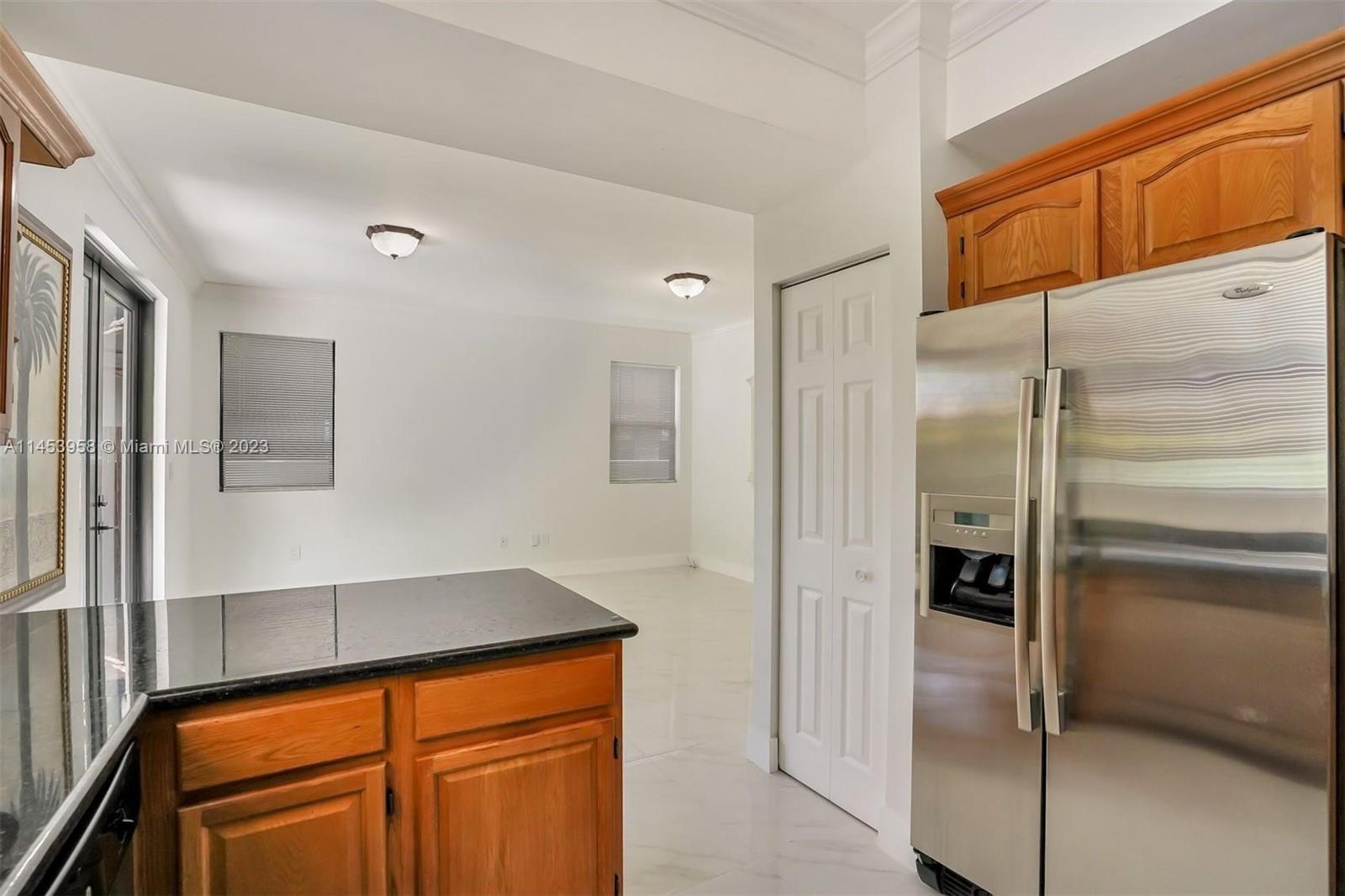 3012 Elizabeth Street, Unit 3012 Miami, FL 33133 - Photo 24 of 27 a kitchen with a refrigerator and cabinets