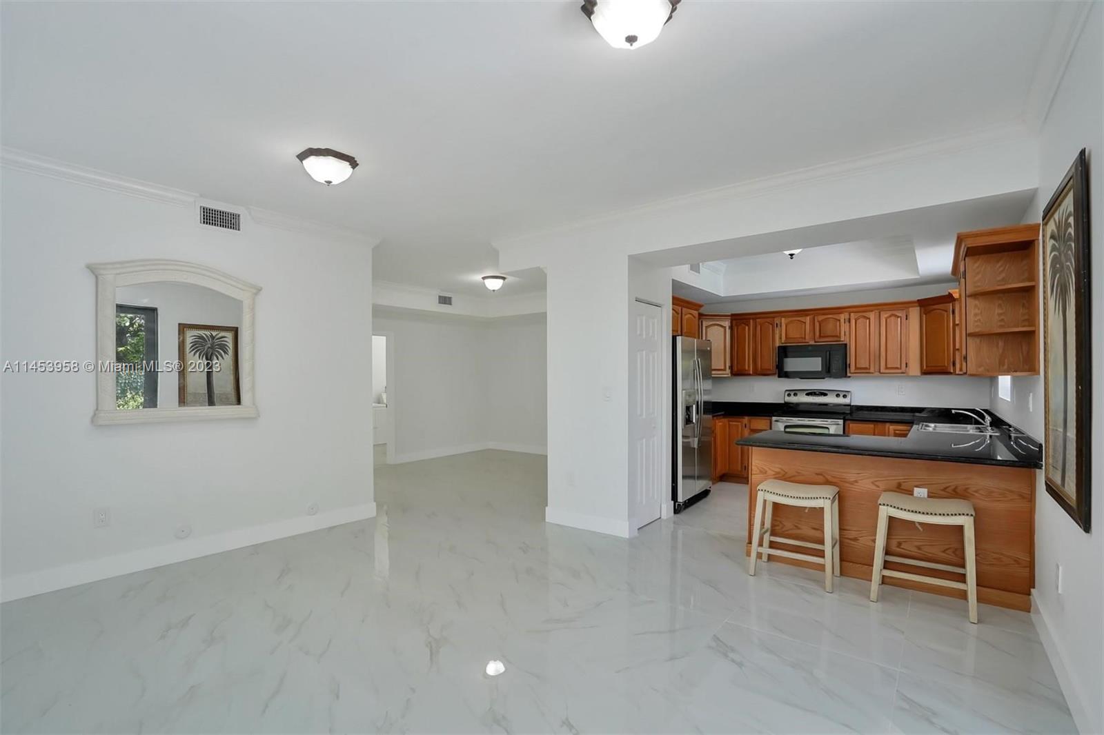3012 Elizabeth Street, Unit 3012 Miami, FL 33133 - Photo 7 of 27 a kitchen with stainless steel appliances granite countertop a stove and a refrigerator