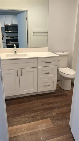 a bathroom with a sink a toilet a vanity and mirror