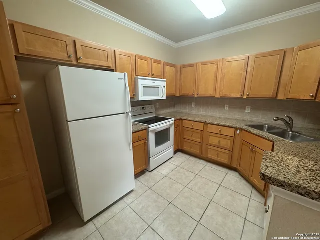 a kitchen with a refrigerator sink and cabinets