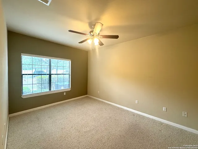 an empty room with a window and a fan