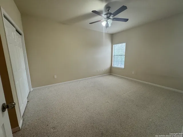 an empty room with closet and fan