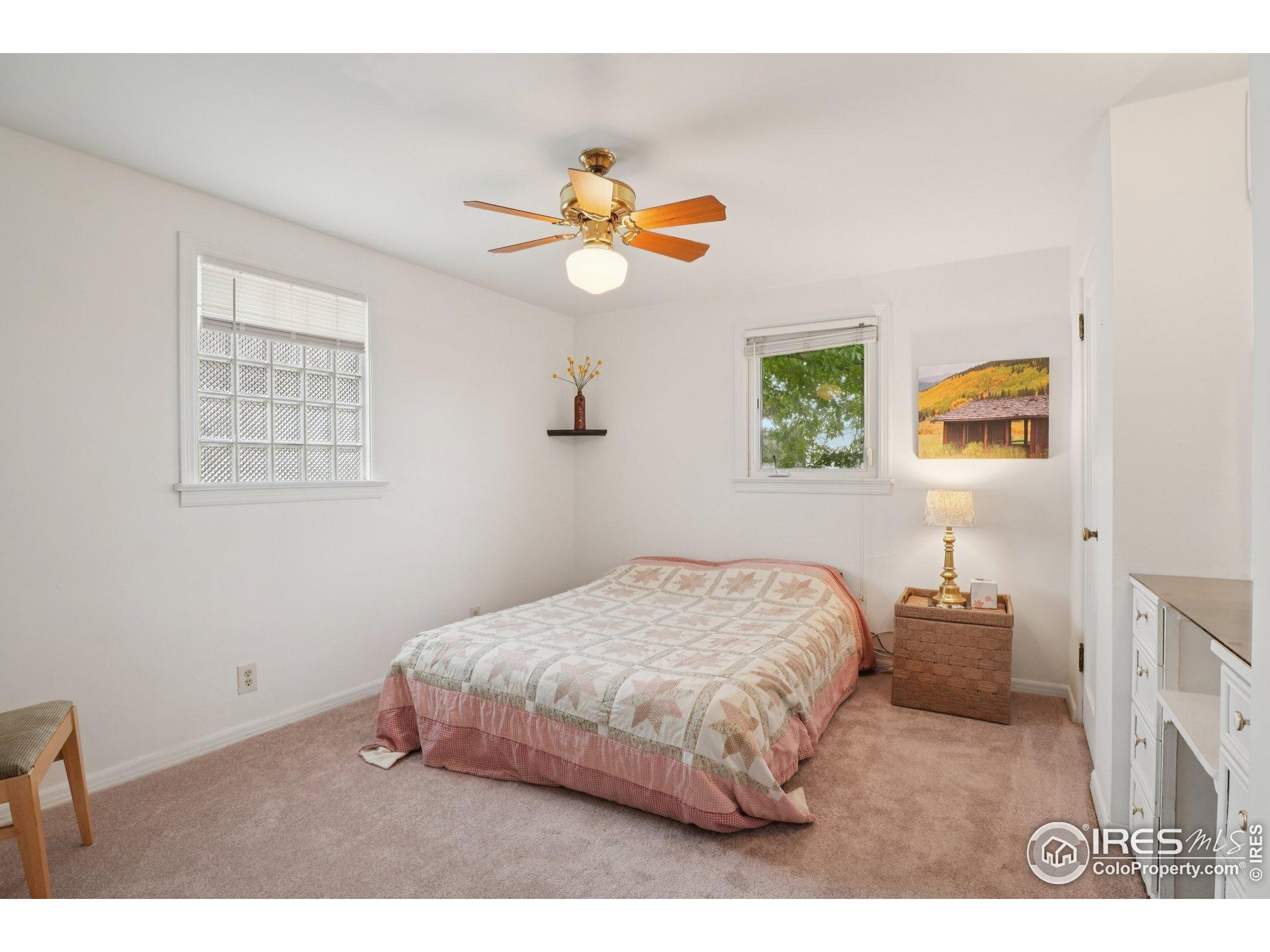 1110 South Quitman Street Denver, CO 80219 - Photo 23 of 43 a bedroom with a bed and a chandelier