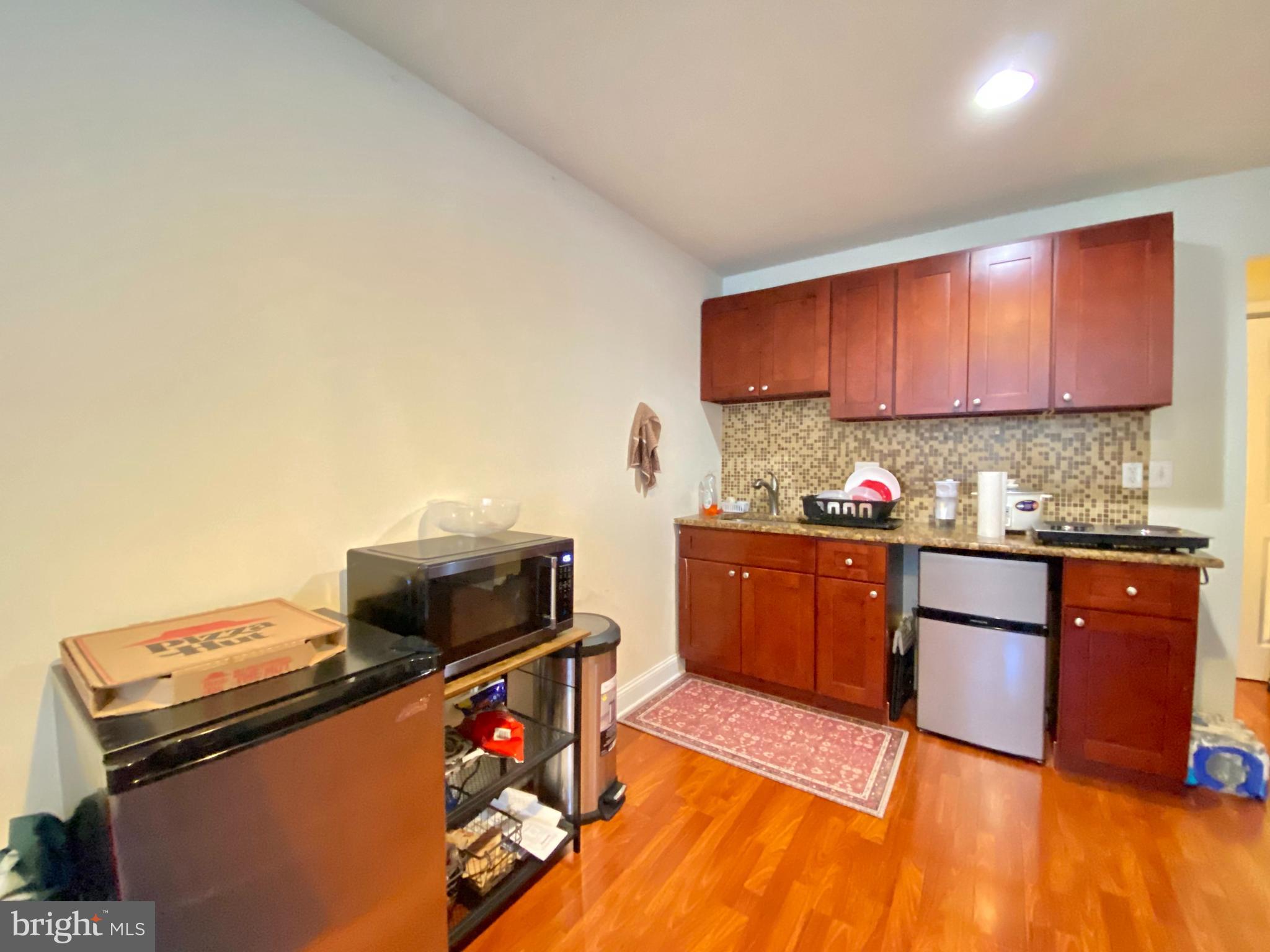1417 North 17th Street, Unit 2F Philadelphia, PA 19121 - Photo 5 of 11 a kitchen with stainless steel appliances granite countertop a stove a sink and a microwave