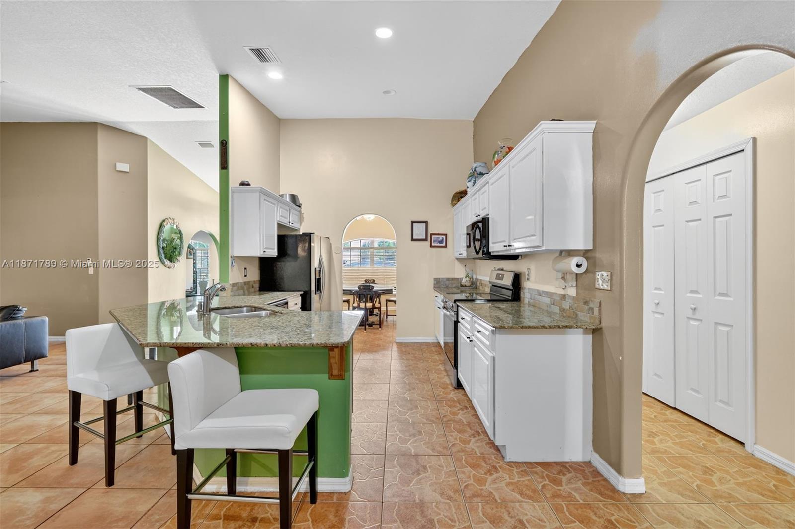 1019 Southwest California Boulevard Port St. Lucie, FL 34953 - Photo 20 of 40 a kitchen with sink cabinets and dining table