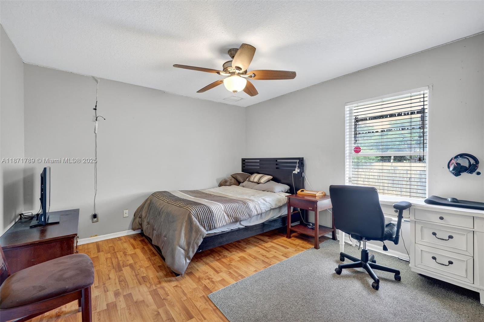 1019 Southwest California Boulevard Port St. Lucie, FL 34953 - Photo 22 of 40 a bedroom with a bed and a chandelier