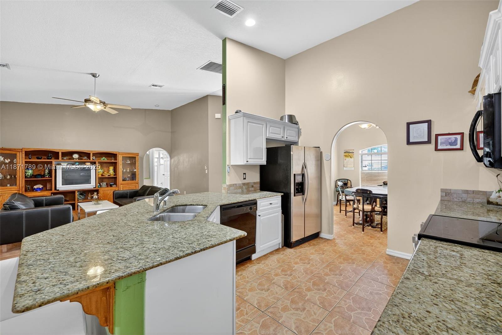 1019 Southwest California Boulevard Port St. Lucie, FL 34953 - Photo 6 of 40 a kitchen with stainless steel appliances granite countertop a stove and a sink