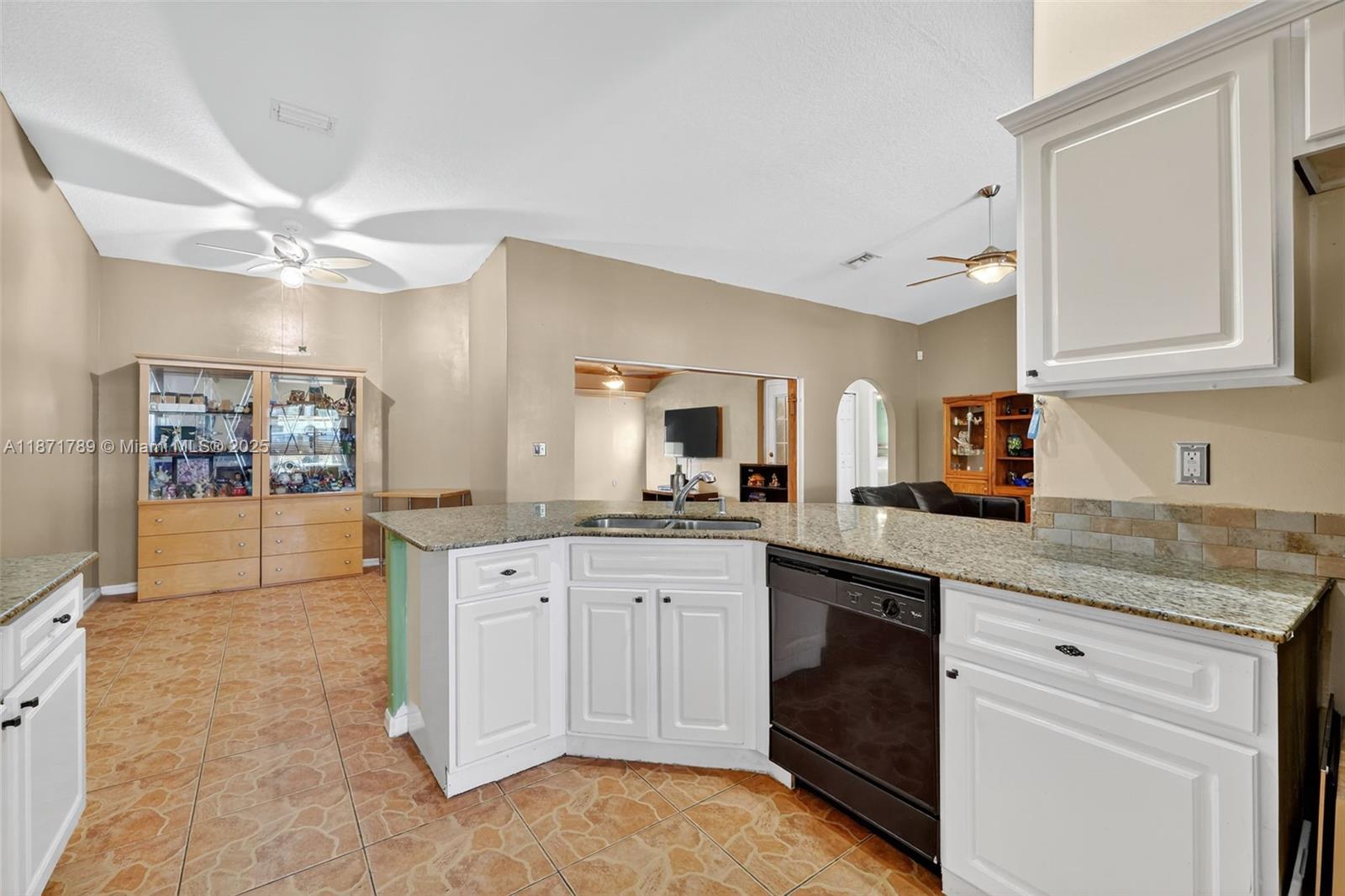 1019 Southwest California Boulevard Port St. Lucie, FL 34953 - Photo 8 of 40 a kitchen with granite countertop a sink stainless steel appliances and cabinets