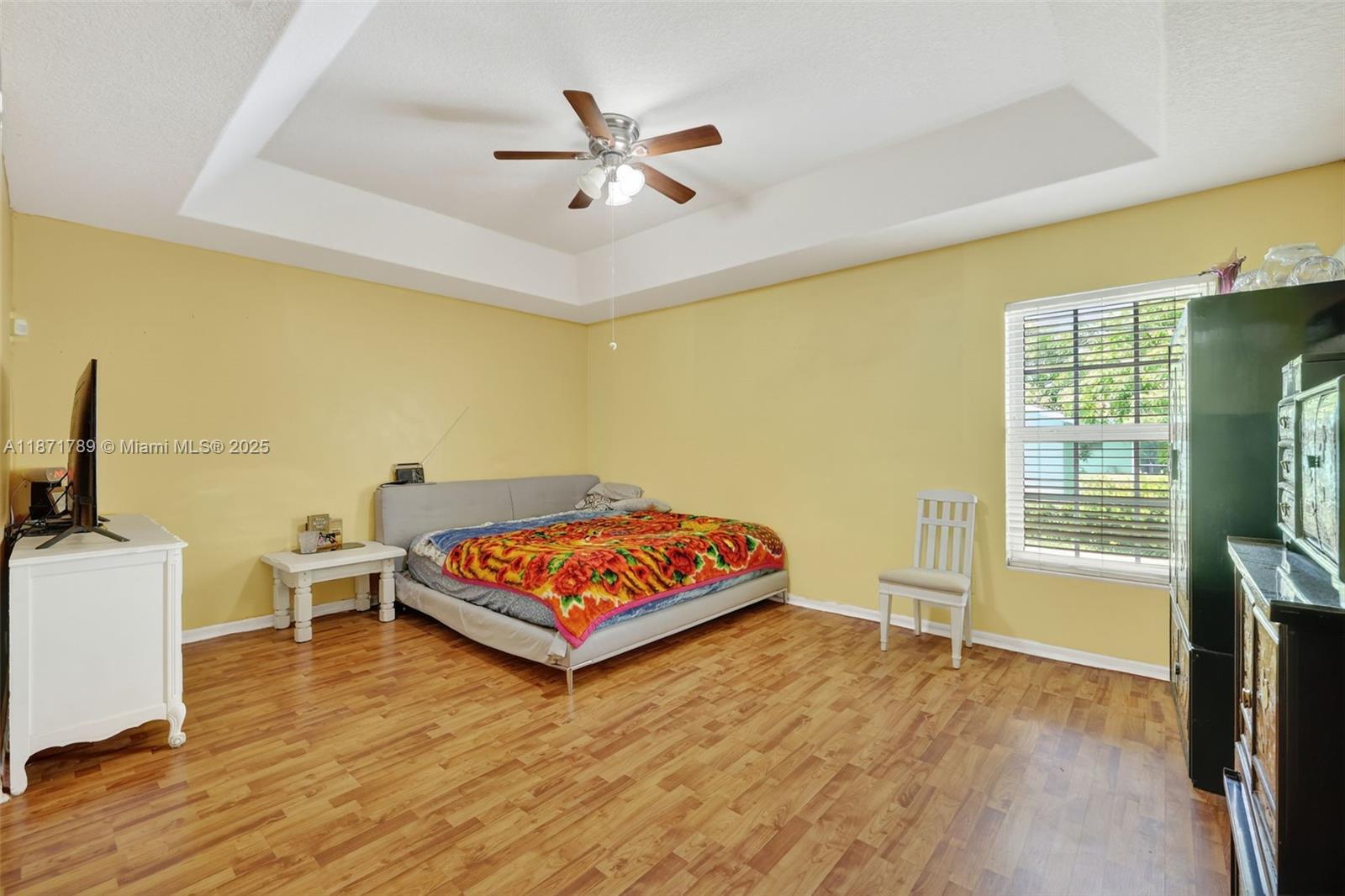 1019 Southwest California Boulevard Port St. Lucie, FL 34953 - Photo 10 of 40 a bedroom with a bed and wooden floor