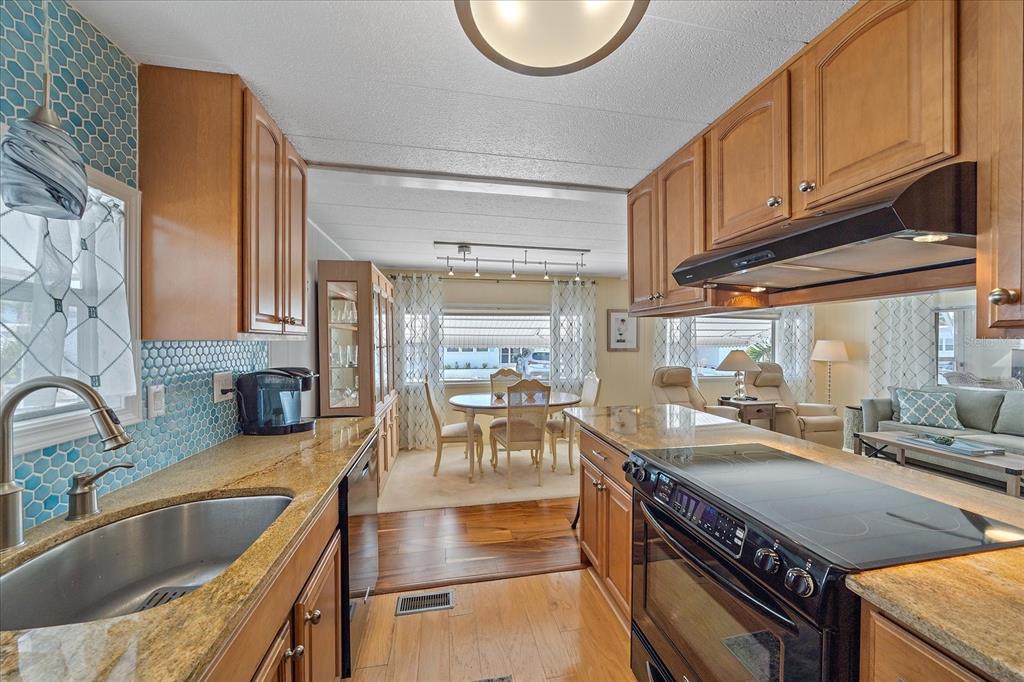 521 Roma Road Venice, FL 34285 - Photo 13 of 57 a kitchen with stainless steel appliances granite countertop a sink stove and cabinets