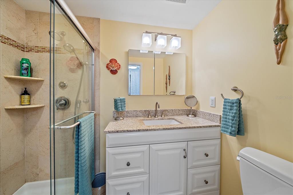 521 Roma Road Venice, FL 34285 - Photo 25 of 57 a bathroom with a granite countertop sink vanity mirror and shower