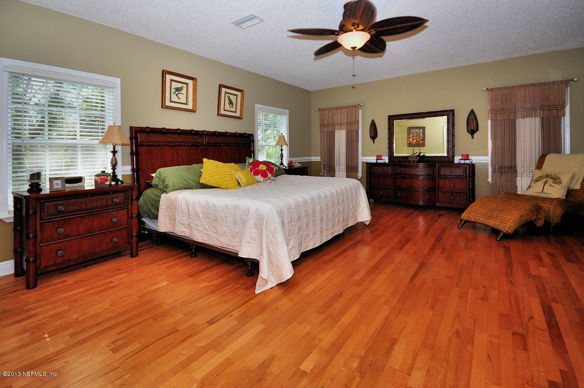 16024 Shellcracker Road Jacksonville, FL 32226 - Photo 14 of 26 a bedroom with a bed and wooden floor