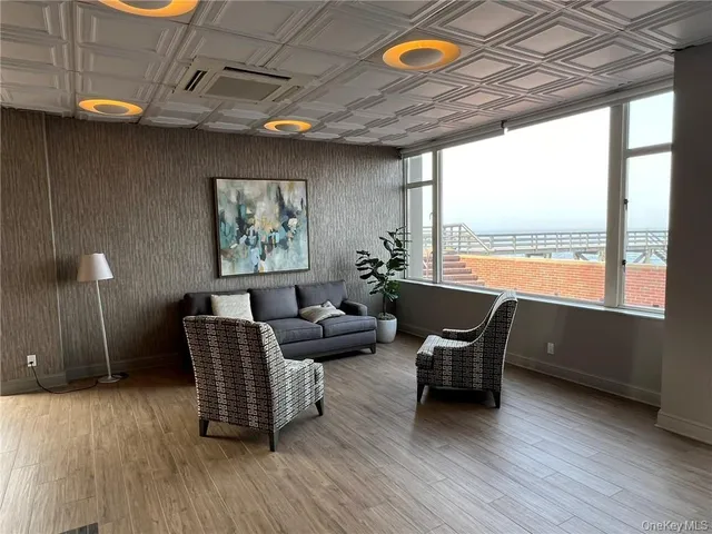a living room with furniture a chandelier and a rug
