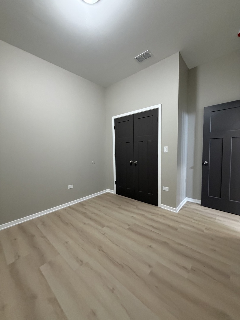 24 North Pulaski Road, Unit 1F Chicago, IL 60624 - Photo 8 of 10 a view of an empty room with wooden floor
