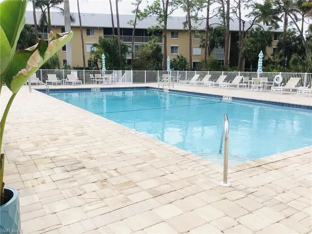 a front view of a house with a yard and palm trees