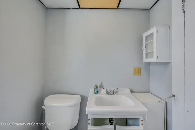 a bathroom with a toilet a sink and mirror