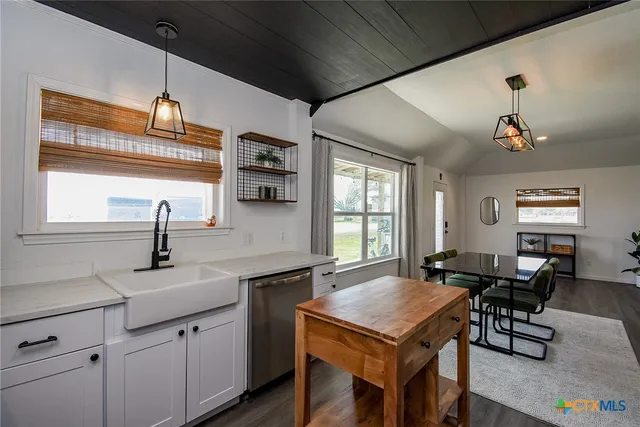 a kitchen with a sink a counter space dining table and chairs