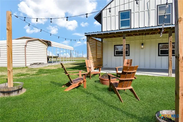 a backyard of a house with table and chairs