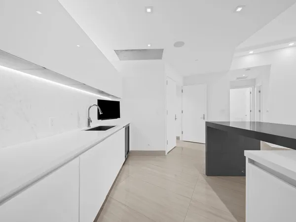 a large white kitchen with a white stove top oven and sink