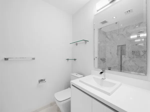 a bathroom with a sink toilet a mirror and shower