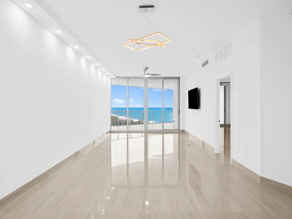 a view of empty room with wooden floor and window