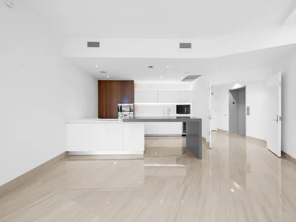 a view of a living room kitchen with stainless steel appliances wooden floor and view living room