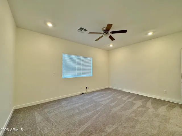 an empty room with a ceiling fan and window