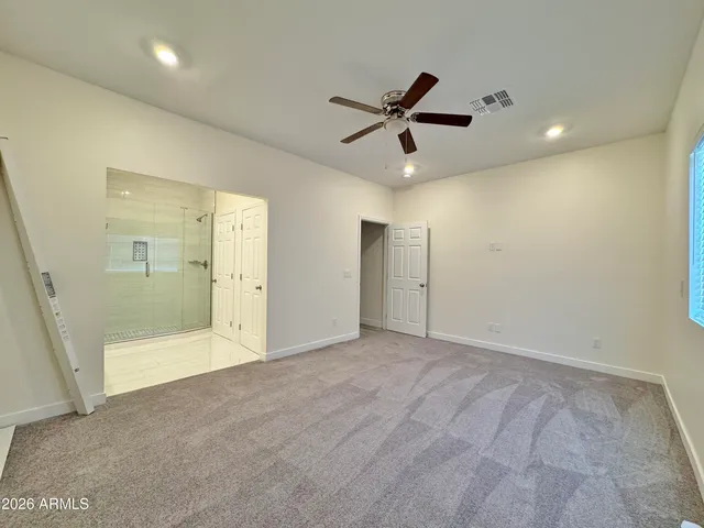 a view of an empty room and a ceiling fan