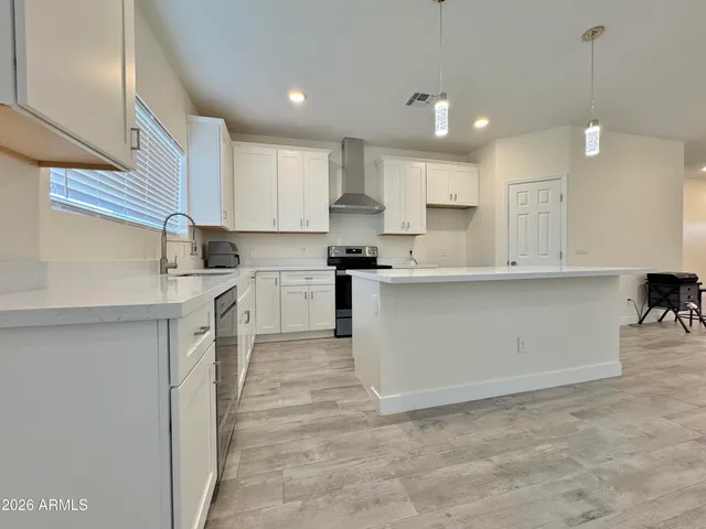 a kitchen with kitchen island sink stove and cabinets