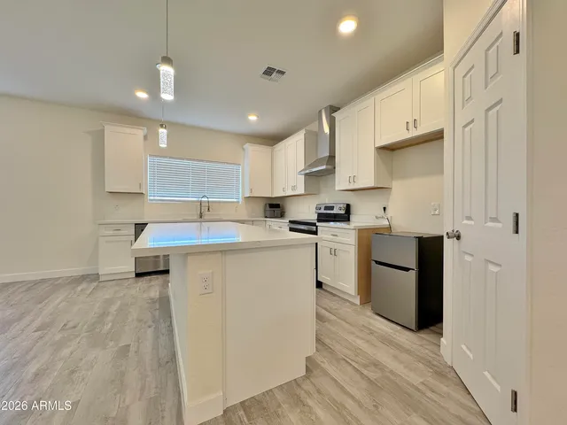 a kitchen with granite countertop a sink cabinets stainless steel appliances and a counter top space