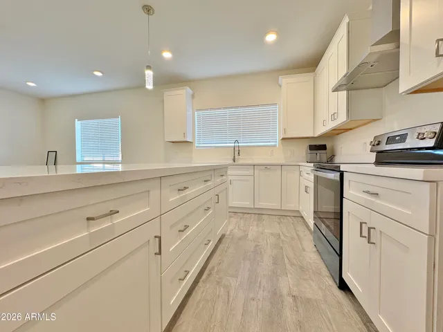 a kitchen with white cabinets appliances and sink