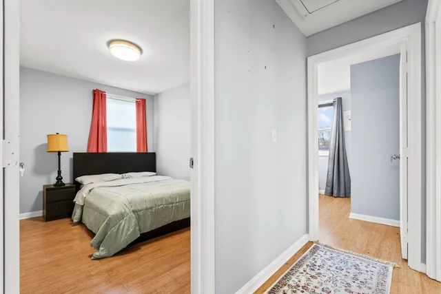 a bedroom with a bed and wooden floor