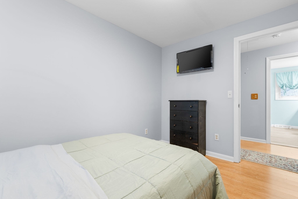 62 Emily Jeffers Road, Unit 62 Randolph, MA 02368 - Photo 18 of 31 a bedroom with a bed and a flat screen tv
