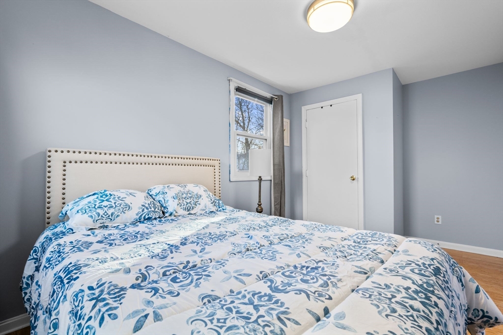 62 Emily Jeffers Road, Unit 62 Randolph, MA 02368 - Photo 21 of 31 a bedroom with a large bed and a chandelier