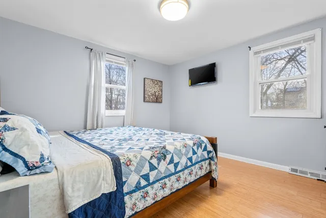 a bedroom with a bed window and flat screen tv