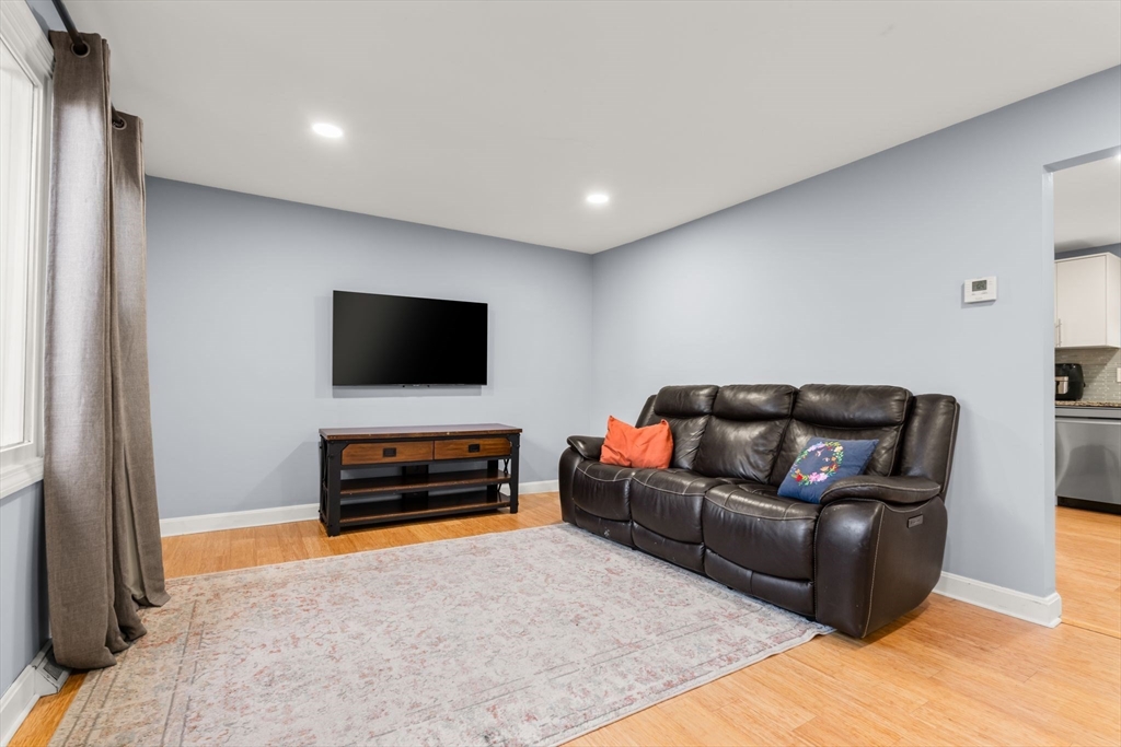 62 Emily Jeffers Road, Unit 62 Randolph, MA 02368 - Photo 26 of 31 a living room with furniture and a flat screen tv