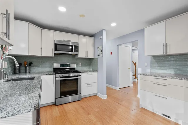 a kitchen with stainless steel appliances granite countertop a stove a sink and a refrigerator