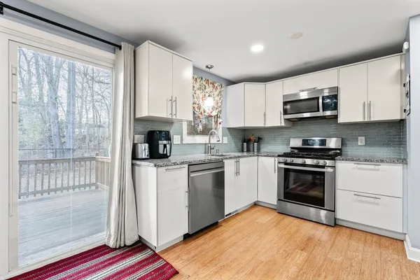 a kitchen with stainless steel appliances granite countertop a stove a sink and a microwave