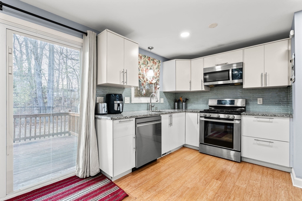 62 Emily Jeffers Road, Unit 62 Randolph, MA 02368 - Photo 7 of 31 a kitchen with stainless steel appliances granite countertop a stove a sink and a microwave