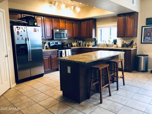 a kitchen with stainless steel appliances granite countertop a refrigerator stove top oven a sink and dishwasher