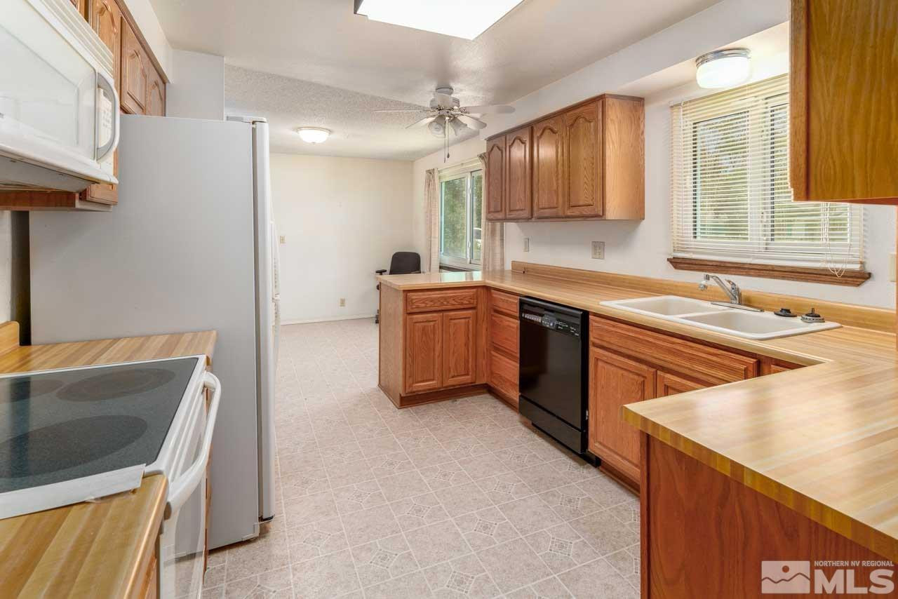 185 Ring Road Dayton, NV 89403 - Photo 7 of 29 a kitchen with stainless steel appliances granite countertop a sink stove and refrigerator