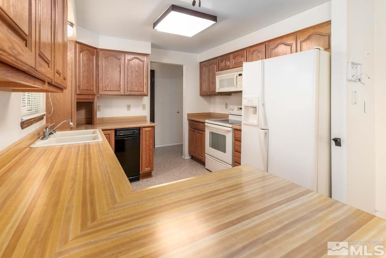 185 Ring Road Dayton, NV 89403 - Photo 8 of 29 a kitchen with stainless steel appliances granite countertop a refrigerator a stove top oven a sink and dishwasher